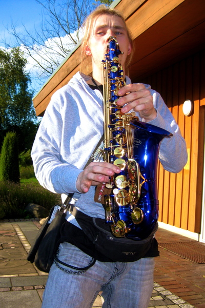 Dennis spielt auf seinem neuen blauen Saxophon